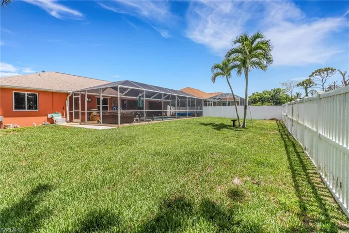 View of fenced-in yard with a patio area, lanai, and grass