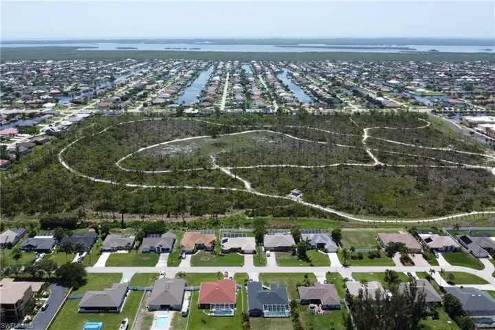 Beautiful aerial view of the home, Joe Coviello Park, and surrounding region featuring the neighborhood, local waters connected to the Gulf, and Pine Island