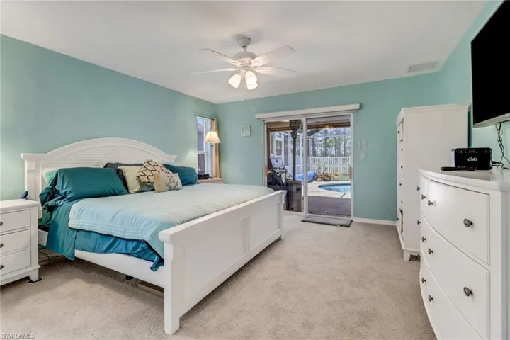 Bedroom featuring access to pool outside, brand new light colored carpet, ceiling fan, and baseboards