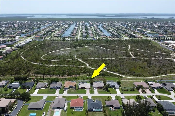 Captivating aerial view of the home, Joe Coviello Park, and surrounding region featuring the neighborhood, local waters connected to the Gulf, and Pine Island