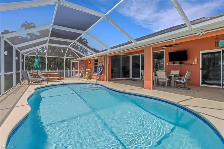 Outdoor pool featuring a patio area, ceiling fan, hot tub, and a lanai