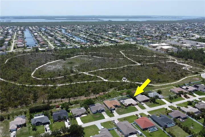 Stunning aerial view of the home, Joe Coviello Park, and surrounding region featuring the neighborhood, local waters connected to the Gulf, and Pine Island