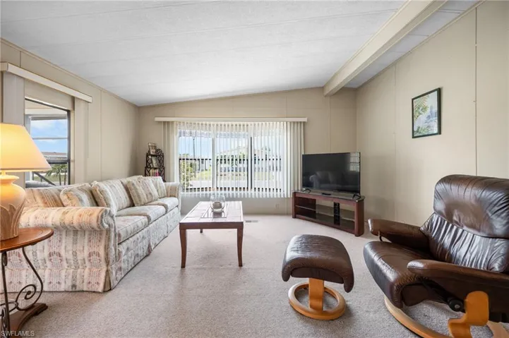 Spacious living area featuring neutral carpeting and light-toned walls