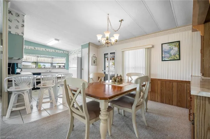 Dining area featuring a chandelier and wood-finish wainscoting