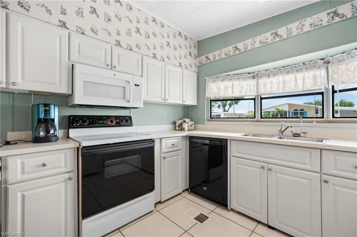 Kitchen featuring white cabinetry, a built-in microwave, an electric range, a double-basin sink, and a dishwasher