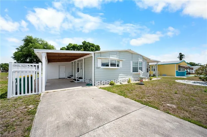 Light blue siding exterior with white trim and a covered carport