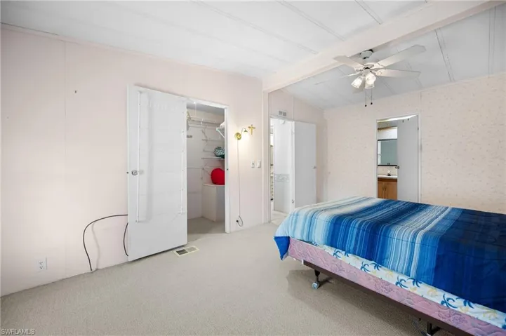 Bedroom featuring neutral carpeting, white paneled ceiling, and a ceiling fan with integrated lighting
