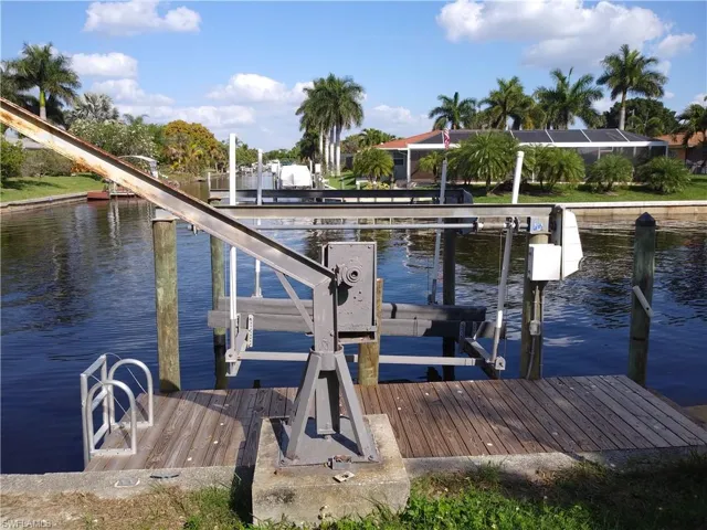 Dock area with boat lift and a water view
