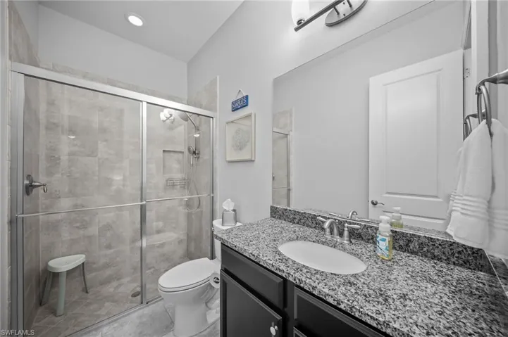 Bathroom with vanity, a shower stall, and light tile patterned floors
