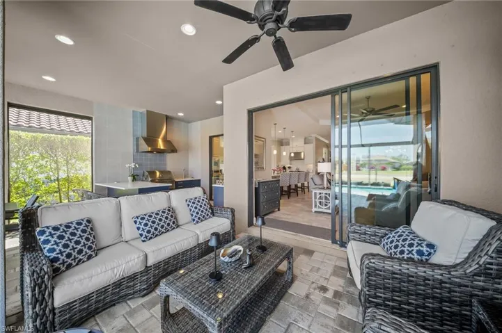 Living area with stone tile flooring, a ceiling fan, and recessed lighting