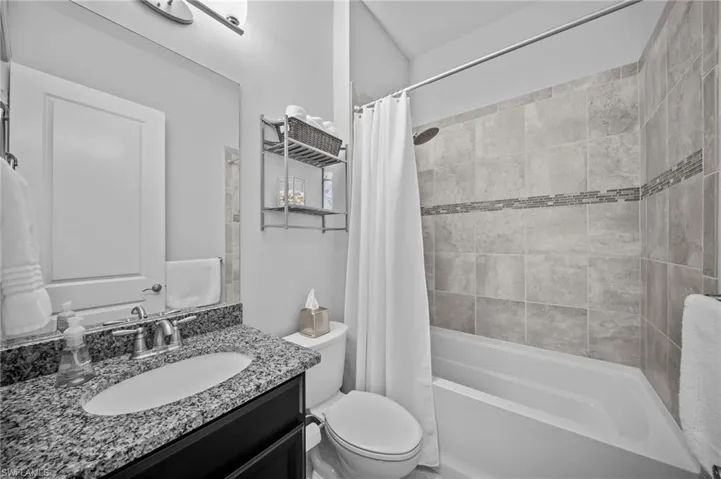 Bathroom with vanity and shower / tub combo with curtain