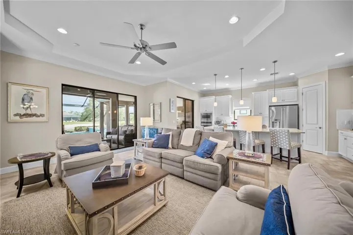 Living area with crown molding, ceiling fan, and recessed lighting