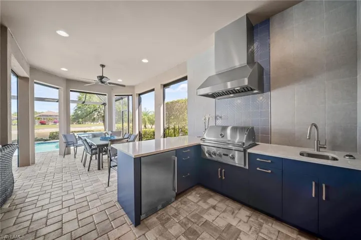 Kitchen with a peninsula, ceiling fan, stainless steel fridge, backsplash, and modern cabinets