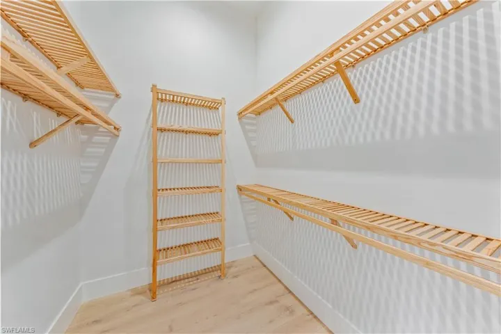 The primary suite features dual walk-in closets complete with copewood closet shelving.