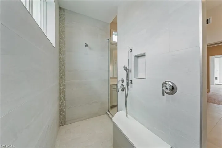 Primary dual-entry shower with dual shower heads and handheld shower