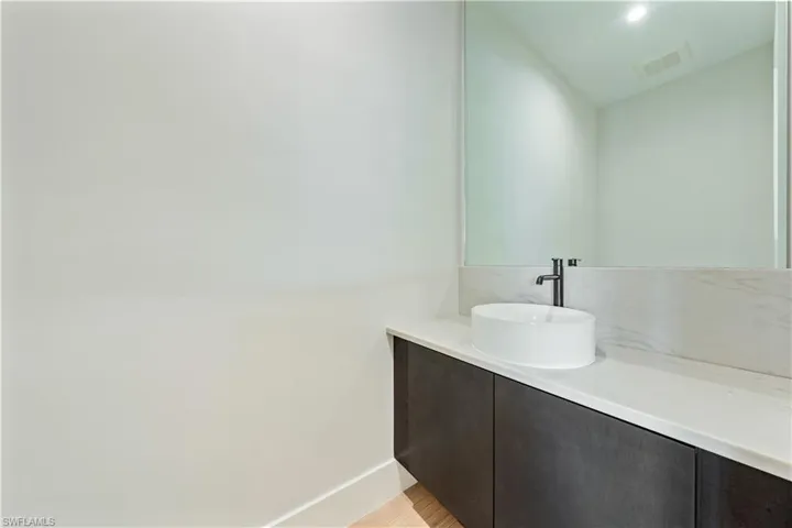A powder bath is tucked away just off of the kitchen. Ceiling pendants will be added to complete the design.