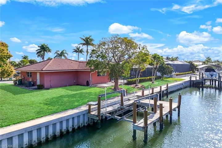 Dock featuring a water view, a yard, and boat lift