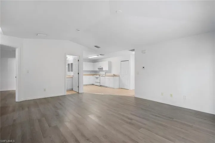 Unfurnished living room with vaulted ceiling and light wood-style floors