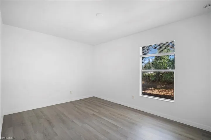 Spare room featuring wood finished floors and baseboards