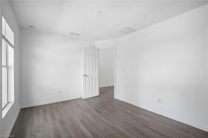 Spare room with plenty of natural light and wood finished floors