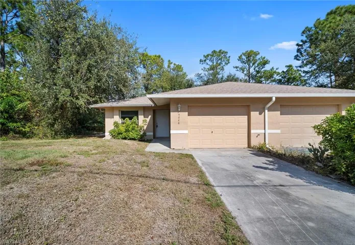 View of front facade with stucco siding, concrete driveway, a garage, roof with shingles, and a front lawn