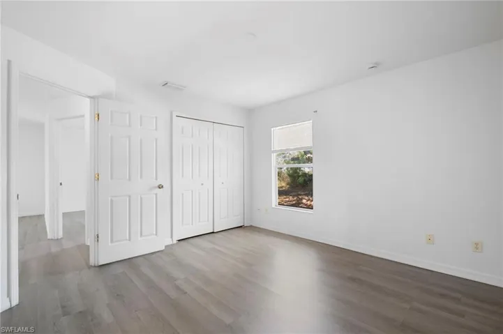 Unfurnished bedroom featuring wood finished floors and a closet