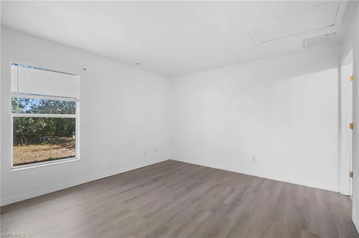 Empty room with wood finished floors and attic access