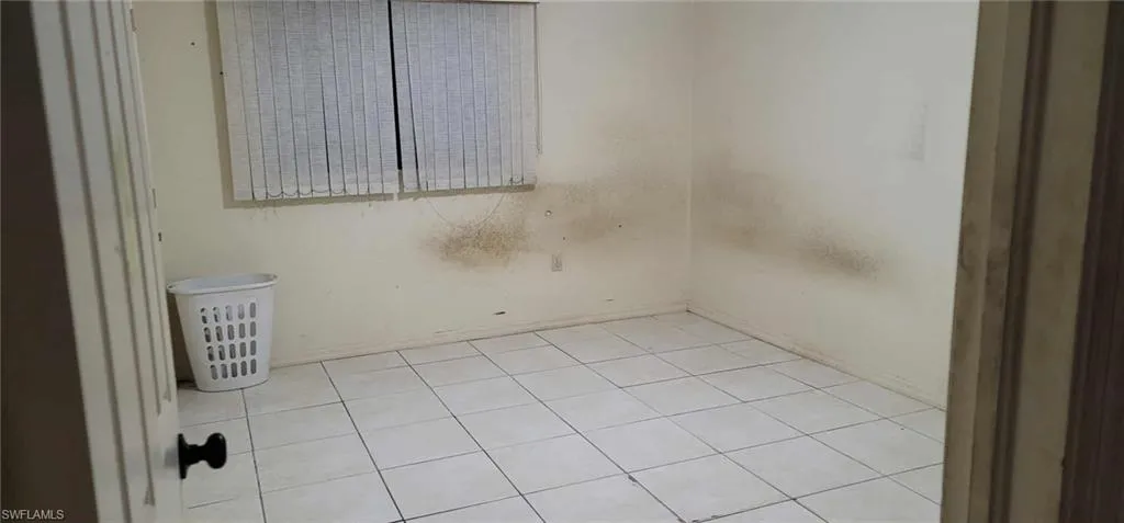 Empty room with light tile patterned flooring