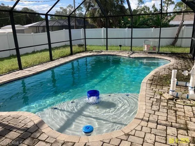 View of swimming pool with a lanai, a fenced backyard, a sunroom, and a patio