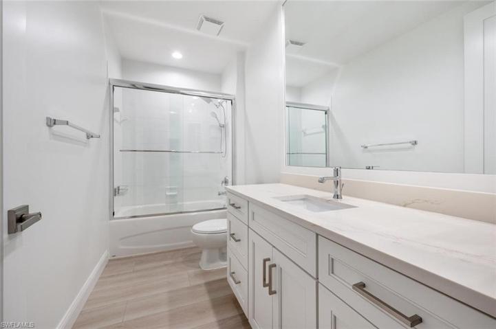 The Guest Bathroom with glass sliding door on the bathtub/shower combo and quartz counter top.
