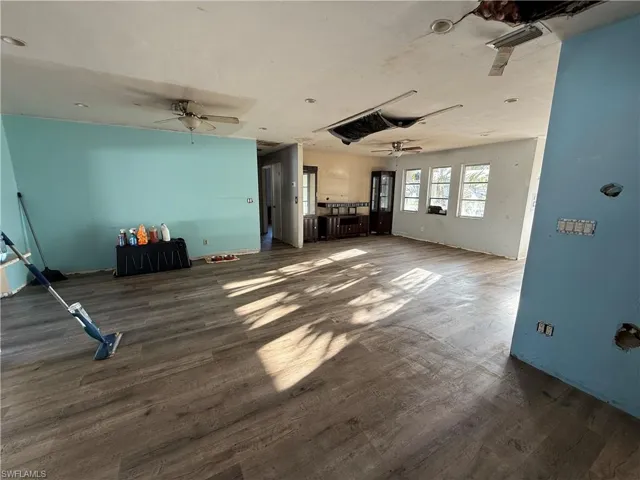 Unfurnished living room featuring dark wood-style flooring