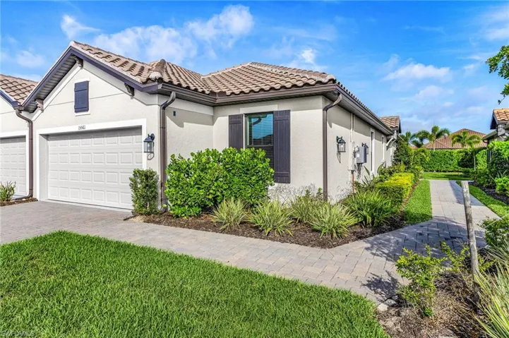 Exterior featuring a tile roof, stucco siding, decorative shutters, and an attached garage