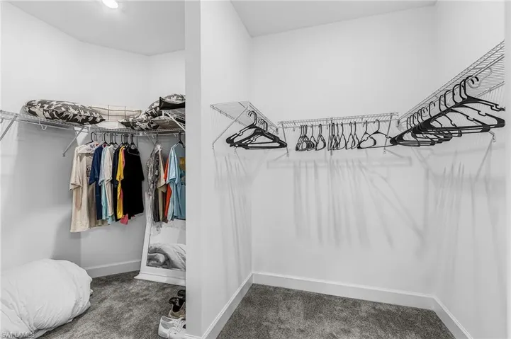 Walk-in closet featuring wire shelving, hanging rods, and recessed lighting