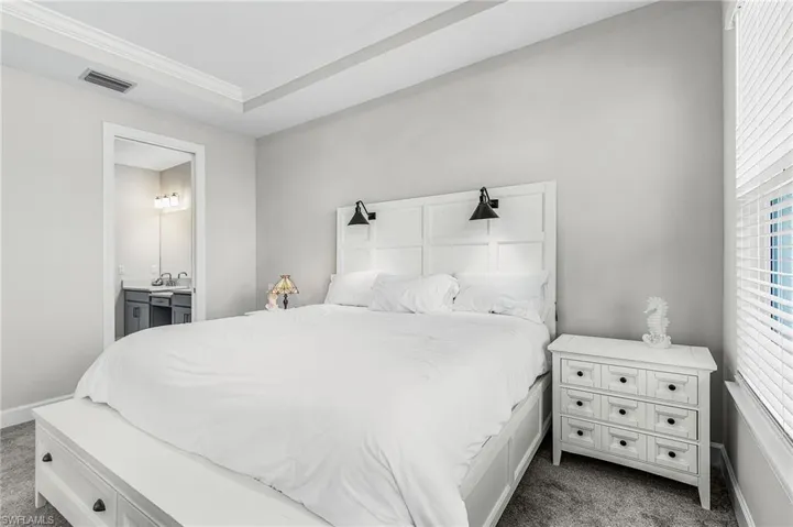 Bedroom featuring a tray ceiling, recessed lighting, and carpet flooring