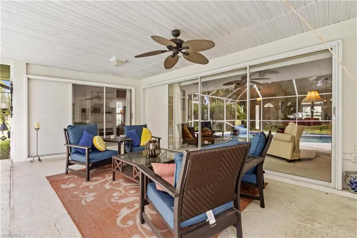 View of patio / terrace featuring glass enclosure, a swimming pool, and ceiling fan