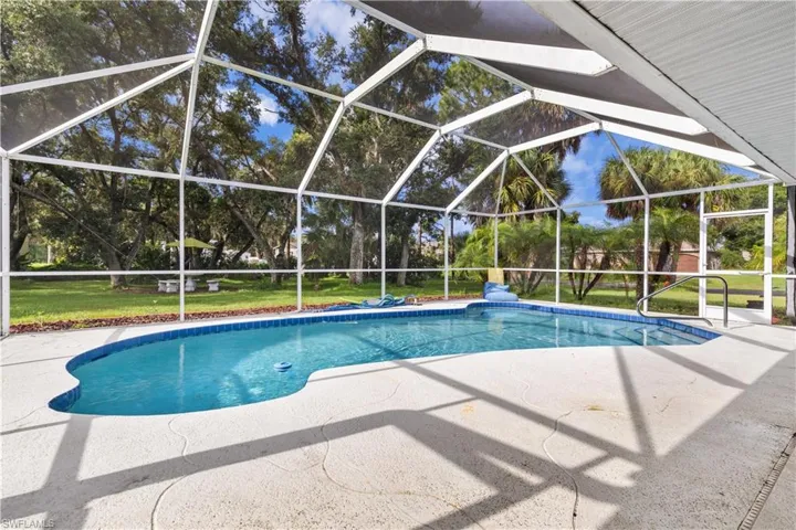 View of pool featuring a lanai, a patio area, and a yard