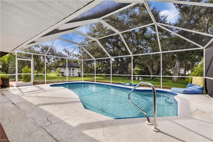 View of swimming pool with glass enclosure, a yard, and a patio area