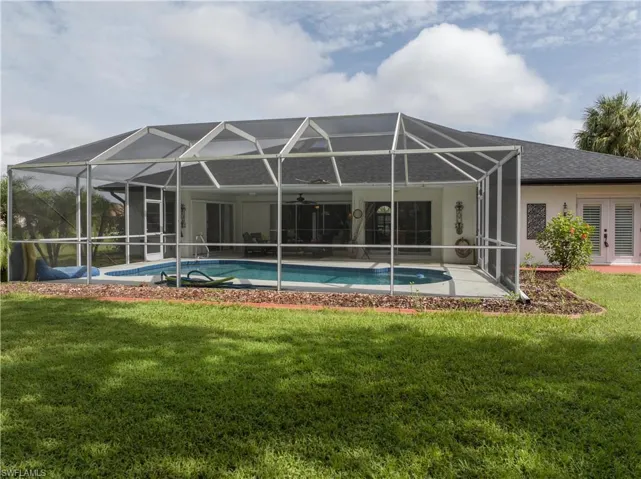 Rear view of property with a yard, a lanai, and a patio