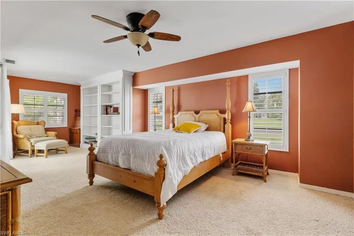 Bedroom featuring carpet flooring, multiple windows, and ceiling fan