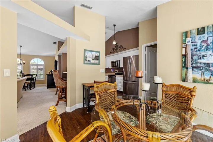 Dining area featuring lofted ceiling, hardwood / wood-style flooring, and a notable chandelier