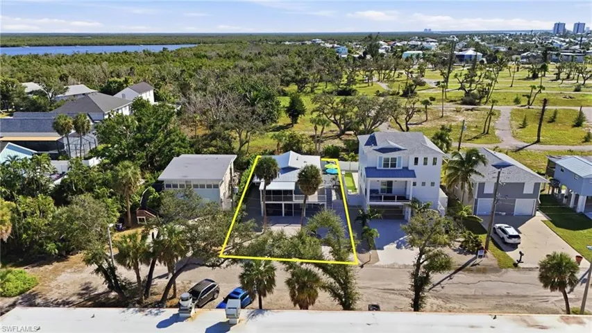 Aerial view of residential area with a large body of water and property parcel outlined- Virtually Edited Image