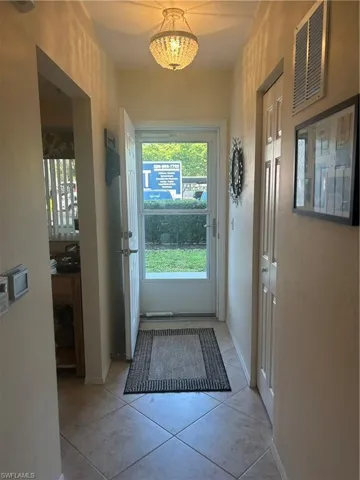 Entryway with tile patterned flooring and baseboards
