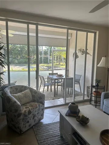 Tiled living area featuring a ceiling fan and plenty of natural light.  Gorgeous view of lake and landscaping.