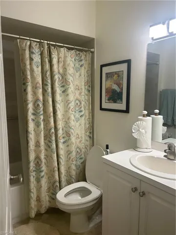 Guest Bathroom featuring vanity, shower / tub combo, and tile patterned flooring