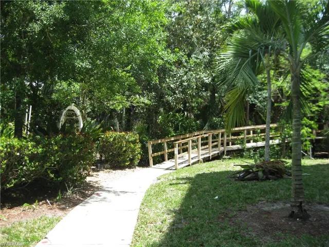 View of property's community walking path and garden entrance.