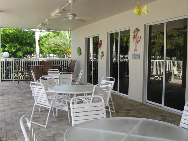 Shaded area under truss at the pool with a fan, dining area, and plenty of shade.
