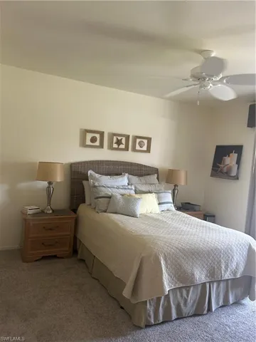 Primary, Carpeted bedroom featuring ceiling fan and queen bed.