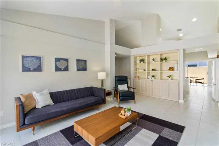 Tiled family room featuring high vaulted ceiling