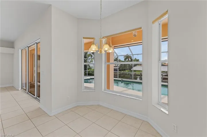 Unfurnished dining area with a notable chandelier and light tile patterned flooring