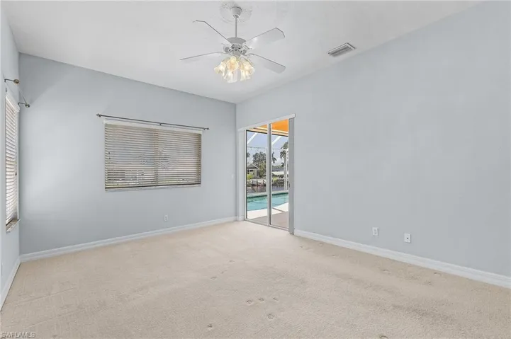 Carpeted empty room with ceiling fan